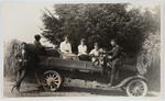 Portrait of a group of men and women in a vehicle.